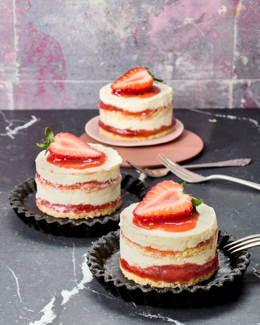 Semifreddo Erdbeer-Rhabarber-Tiramisù-Törtchen mit GLÜCK aus Erdbeer-Rhabarber, garniert mit einer frischen Erdbeere.