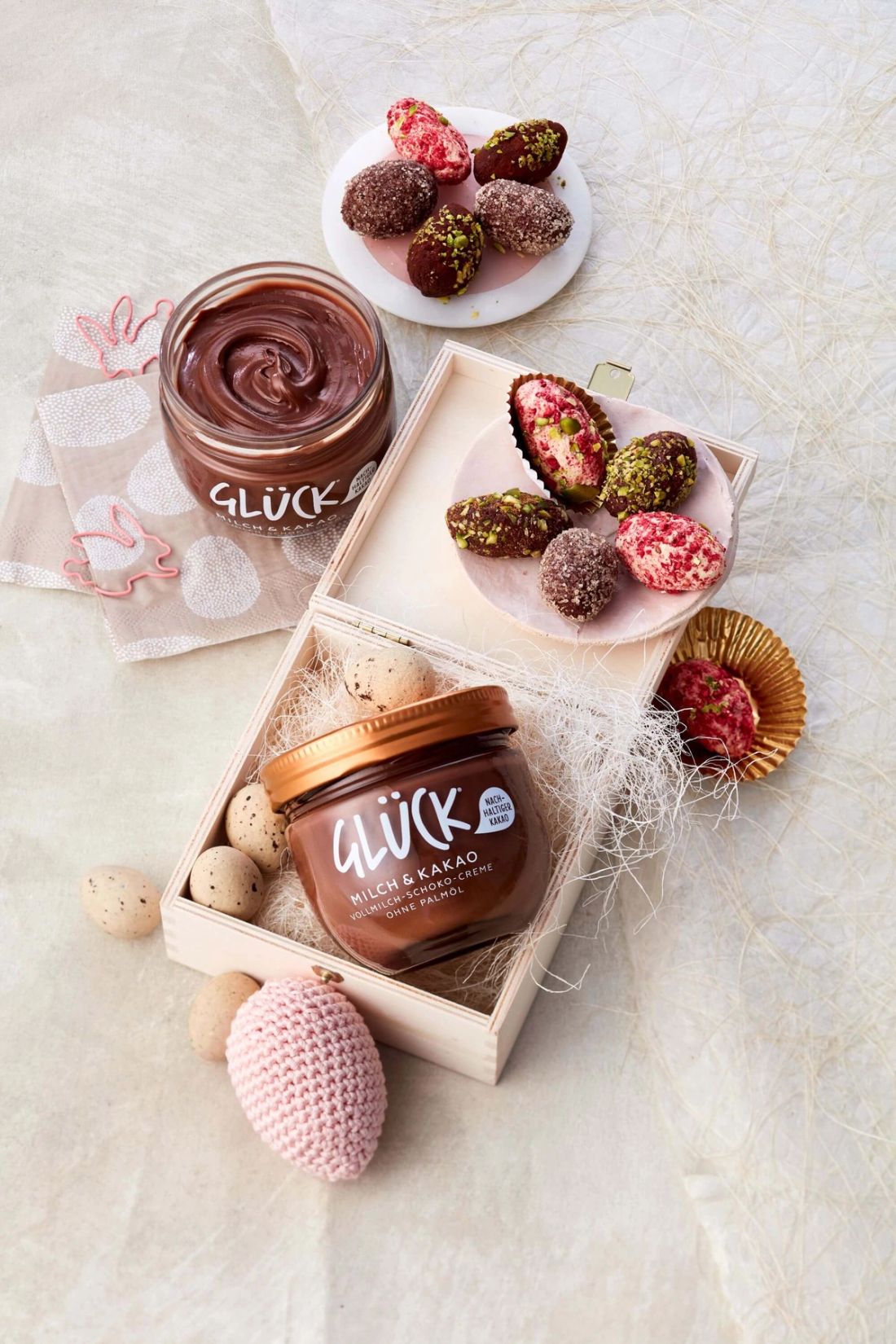 Kakao und Mandel Trüffel Pralinen mit Osterdekoration und einem Glas GLÜCK Milch & Kakao.