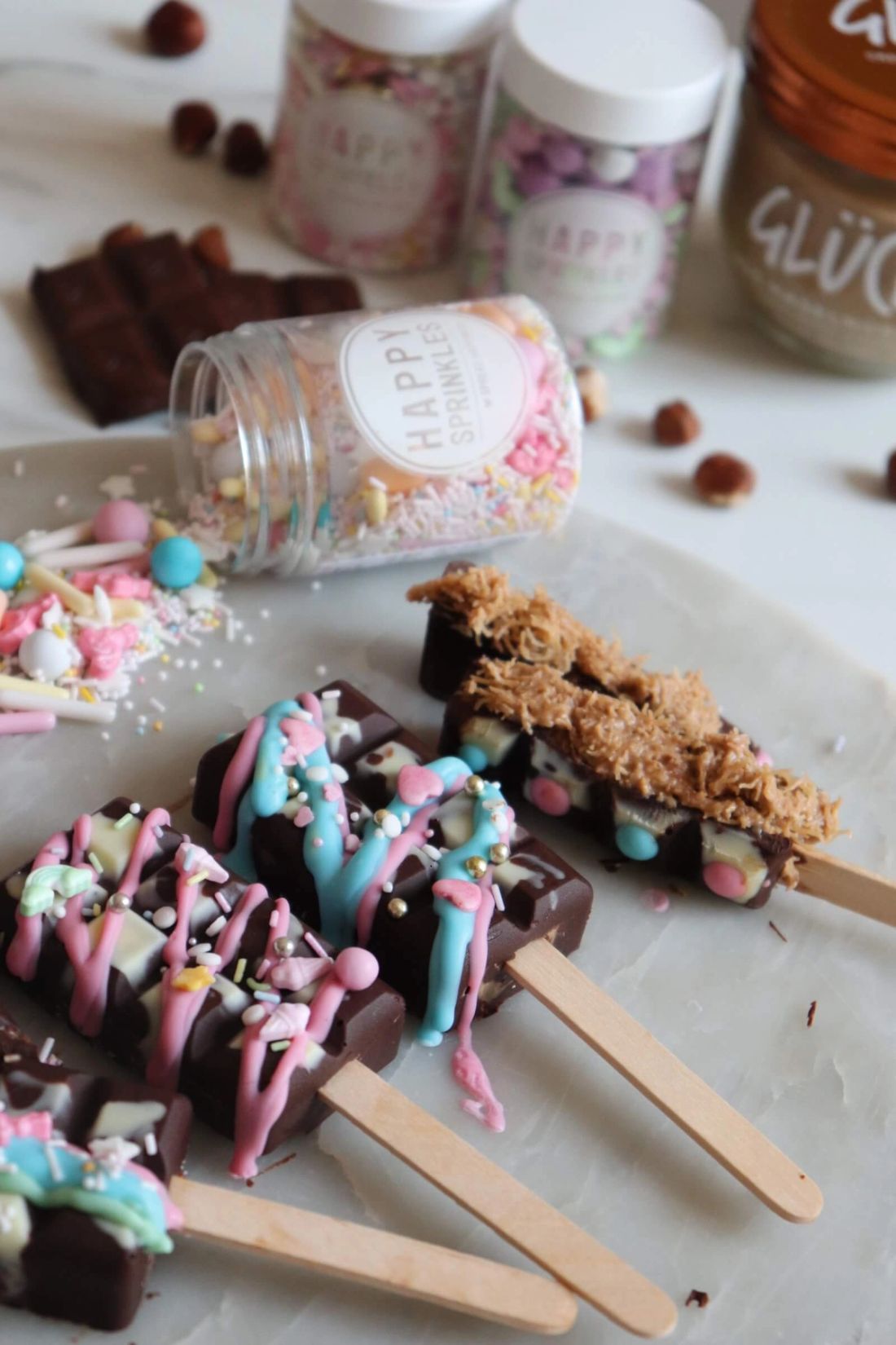 Dubai Schokolade am Stiel, verziert mit bunter Schokolade und Streuseln von Happy Sprinkles.