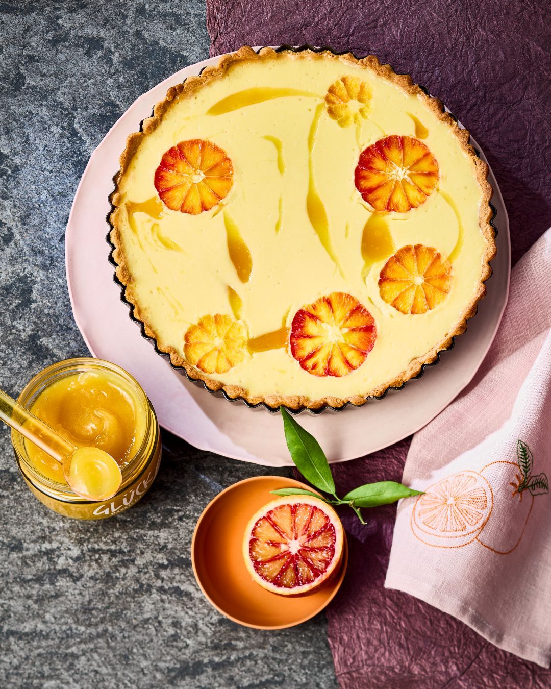 Orangen-Ricotta-Tarte, garniert mit frischen Orangen und GLÜCK passiert aus Süßorangen.