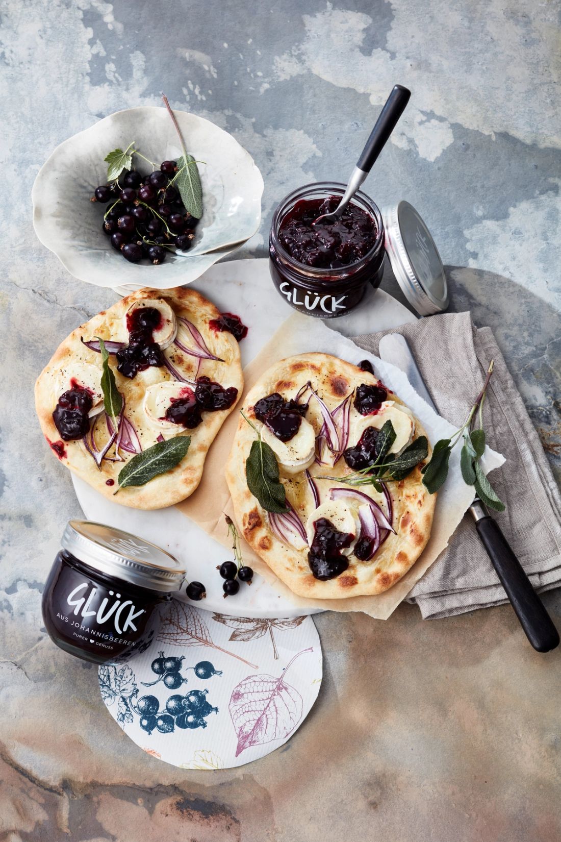 Herzhaft-süßer Flammkuchen mit Ziegenkäse, Salbei, Zwiebeln und GLÜCK aus Johannisbeeren.