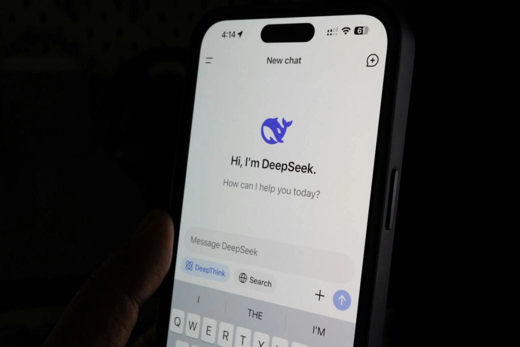 A close-up image of a smartphone displaying a chat interface for an application called DeepSeek. The screen shows a greeting message and a prompt for user interaction. — Credit: Photo by Solen Feyissa / Unsplash