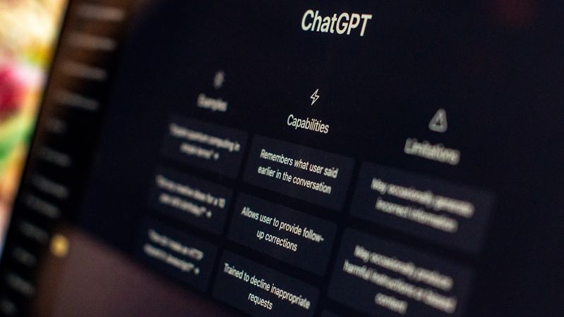 The image shows a close-up of a computer screen displaying the ChatGPT interface. Various options and features of the AI tool are highlighted, emphasizing its capabilities and limitations.