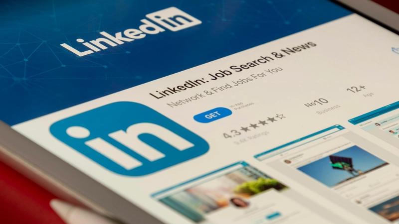 The image shows a close-up of a tablet displaying the LinkedIn app interface. It highlights the app's features for job searching and networking.