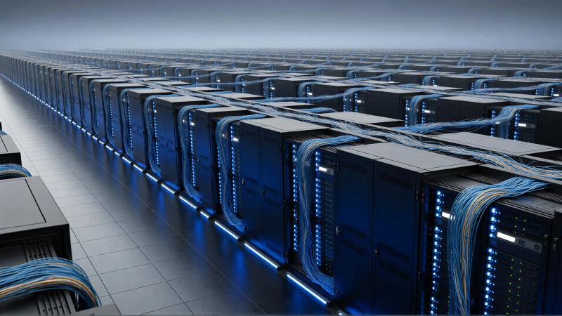 The image depicts a cavernous data center filled with rows of server racks. Blue LED lighting highlights the network cables connecting the servers, creating a modern and high-tech environment.