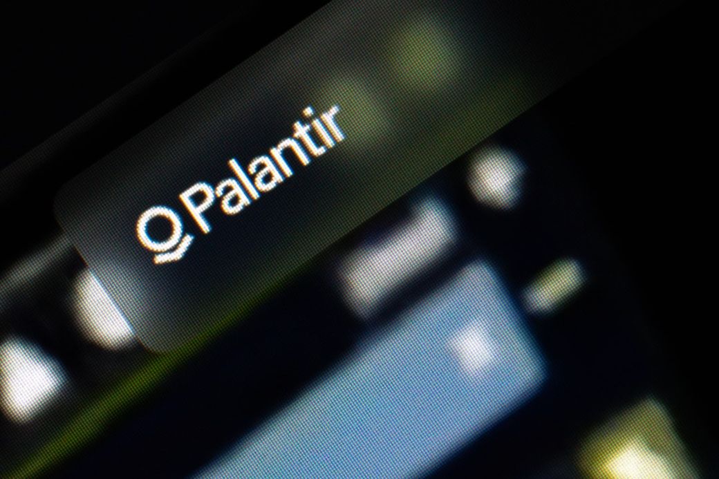 The image features a close-up of a digital display showing the word 'Palantir', suggesting a connection to data analytics or software technology. The background is blurred, indicating that it is likely from a computer screen or interface. — Credit: Photo by Salvador Rios on Unsplash