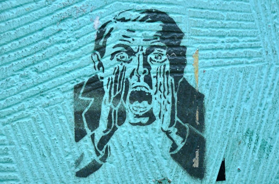 The image features a stencil graffiti art depicting a man screaming with his hands cupped around his mouth. The background is a textured turquoise surface that enhances the boldness of the artwork.