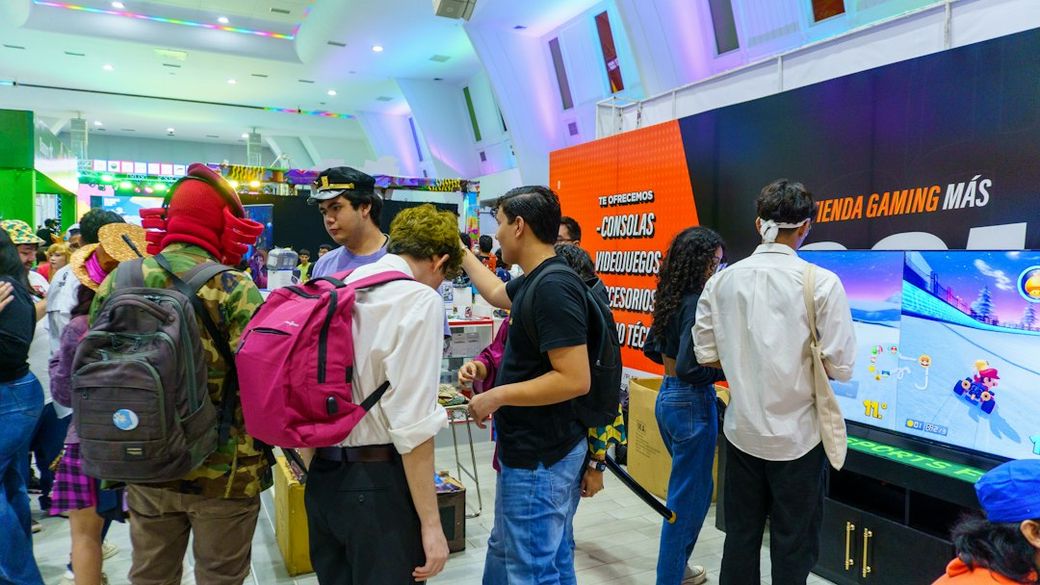 A lively gaming event featuring a colorful booth with attendees engaging in various gaming activities. Participants are dressed in casual attire, with several wearing costumes, indicating a festive atmosphere. — Credit: Photo by Les Taylor on Unsplash