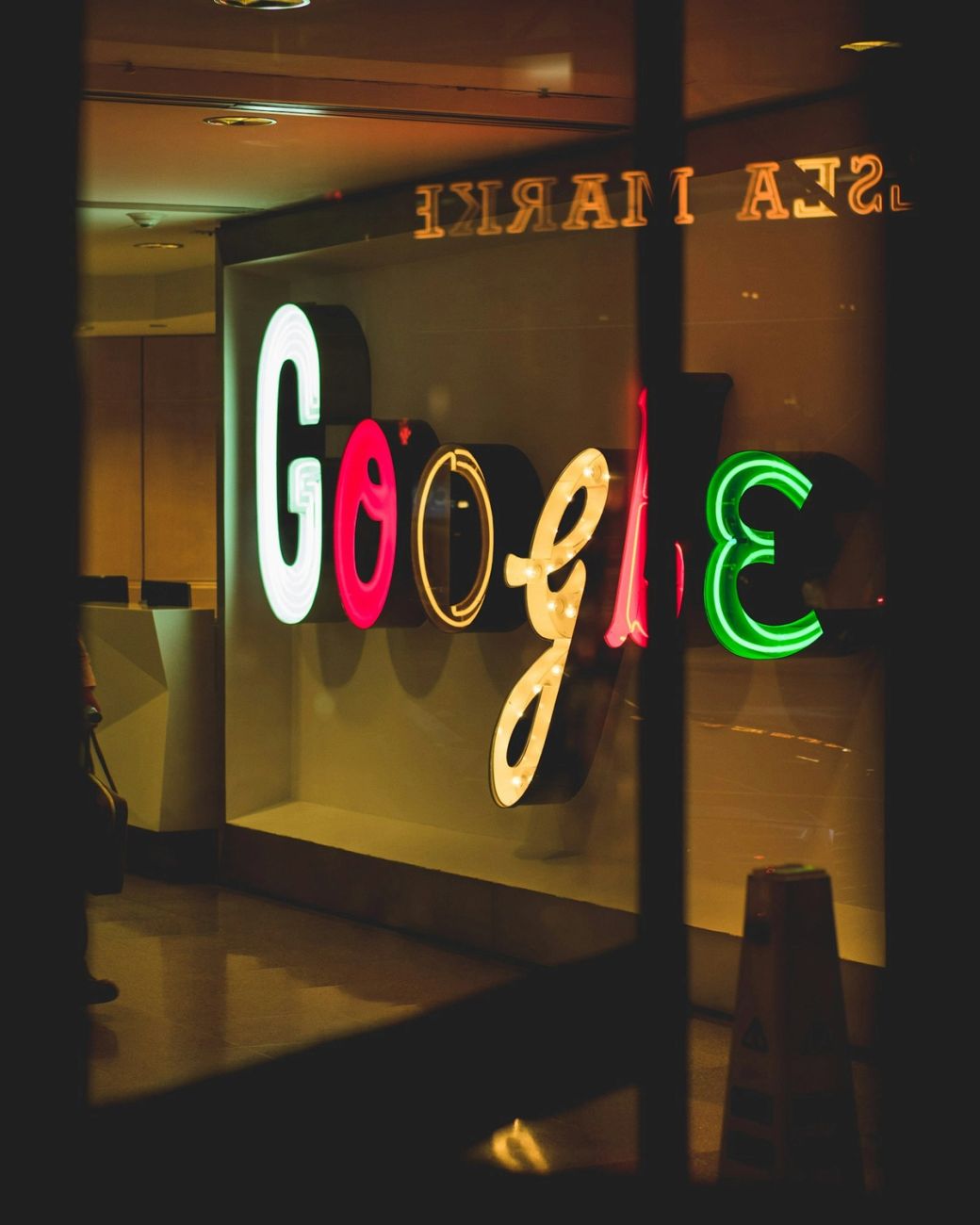 The image showcases the illuminated and colorful signage of Google, featuring different colored letters in a decorative style. The bright lights create a vibrant and inviting atmosphere around the brand's name. — Credit: Photo by Arthur Osipyan / Unsplash