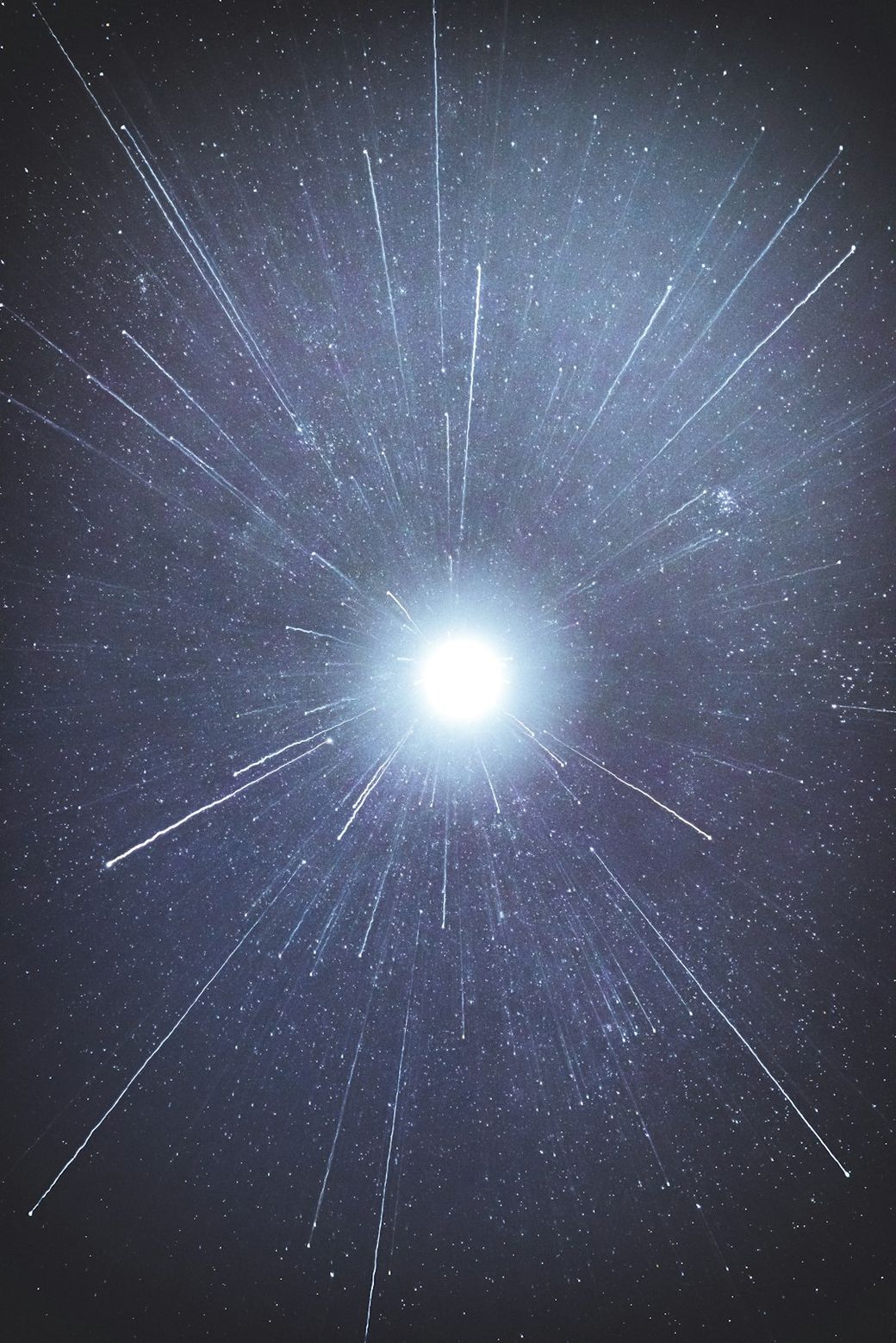 The image depicts a bright central light surrounded by a dark backdrop, creating an effect that resembles rays of light emanating outward. The composition suggests a cosmic or ethereal theme, evoking a sense of vastness and depth in space. — Credit: Photo by Casey Horner on Unsplash