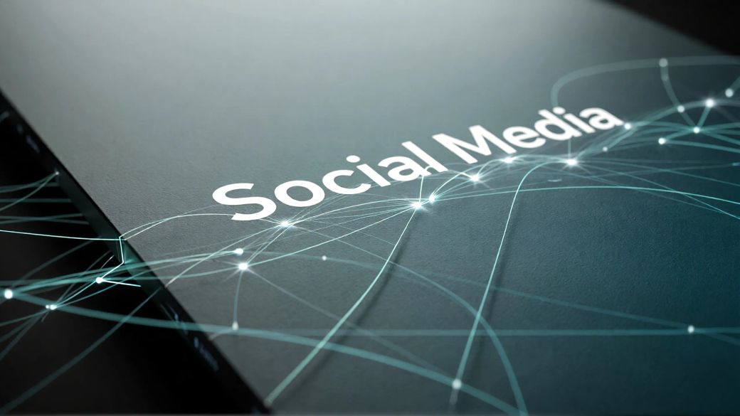 The image features a close-up view of a dark surface with the text 'Social Media' prominently displayed. The background includes a digital design with interconnected lines and light nodes, suggesting a technological theme.