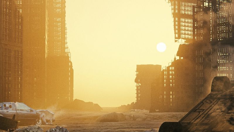 The image depicts a desolate cityscape at sunset, featuring partially destroyed skyscrapers and abandoned vehicles. The sun is low on the horizon, casting a dramatic glow over the scene, highlighting the remnants of a once-bustling urban environment.
