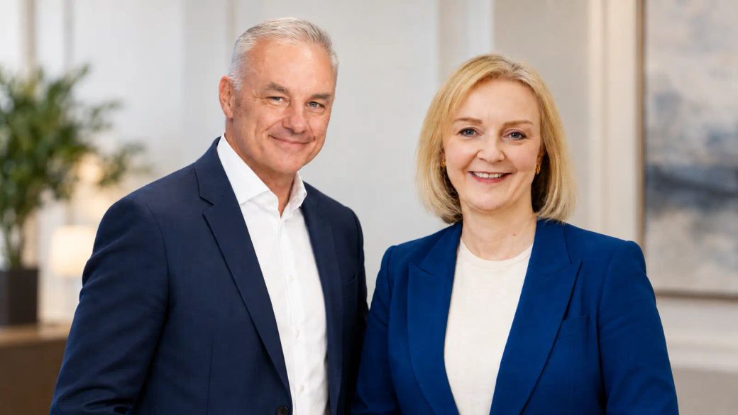 A professional portrait featuring two individuals, a man and a woman, smiling confidently at the camera. They are dressed in formal attire, suggesting a professional or corporate setting.