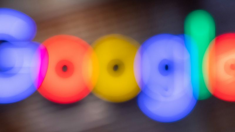 The image features a blurred representation of the Google logo, created with vibrant colored lights. The colors include blue, red, yellow, and green, giving it a lively and modern appearance.