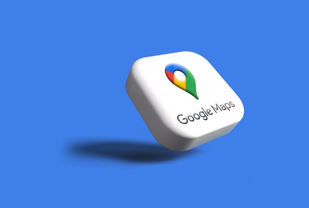 This image features a 3D representation of the Google Maps logo set against a solid blue background. The logo is prominently displayed with its recognizable pin and color scheme, emphasizing the location-based service offered by Google. — Credit: Photo by Rubaitul Azad on Unsplash