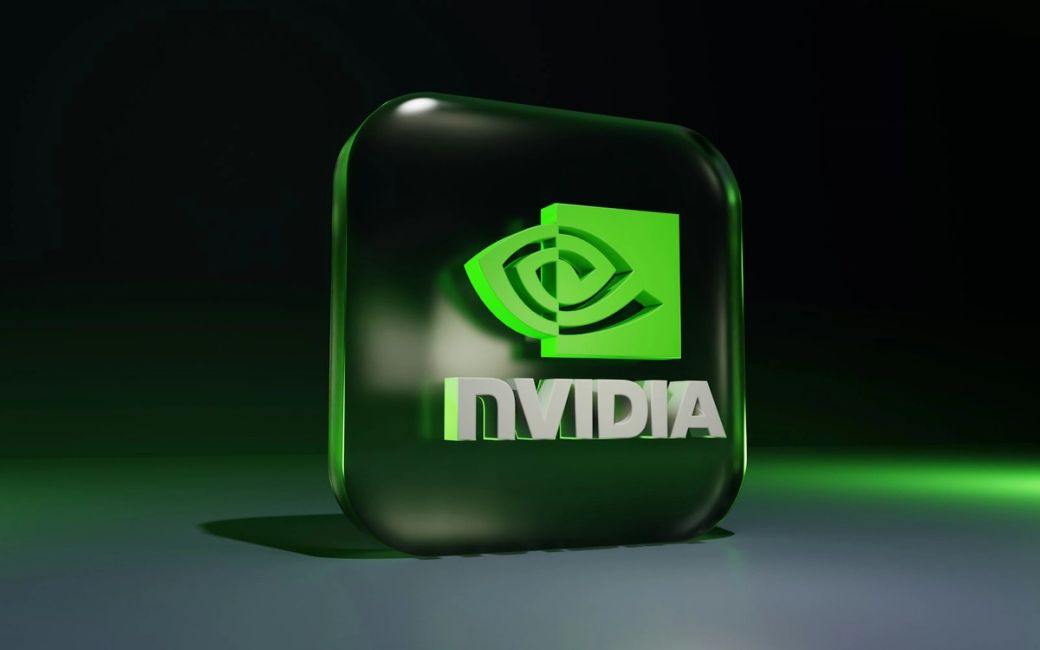 The image features a 3D representation of the NVIDIA logo, which is depicted on a glossy green background. The logo is prominently displayed, reflecting light, emphasizing the brand's identity in the tech industry. — Credit: Photo by BoliviaInteligente / Unsplash