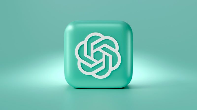 The image features a three-dimensional cube with a smooth, turquoise surface. The cube is embossed with a white, stylized logo that resembles an interlocking design, suggesting a modern technological theme.