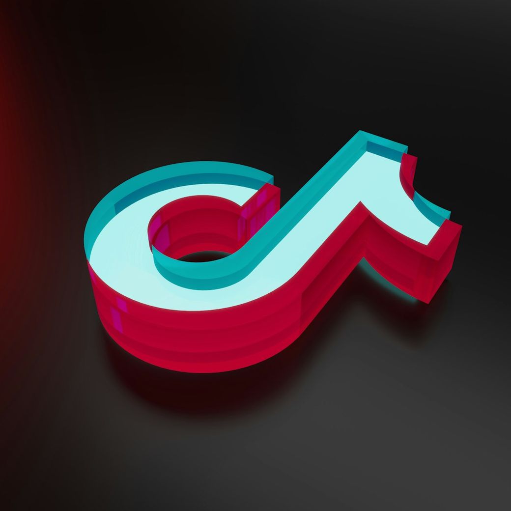The image features a stylized logo in a three-dimensional design. The logo appears in a vibrant color scheme of blue and red, set against a dark background. — Credit: Photo by Eyestetix Studio on Unsplash