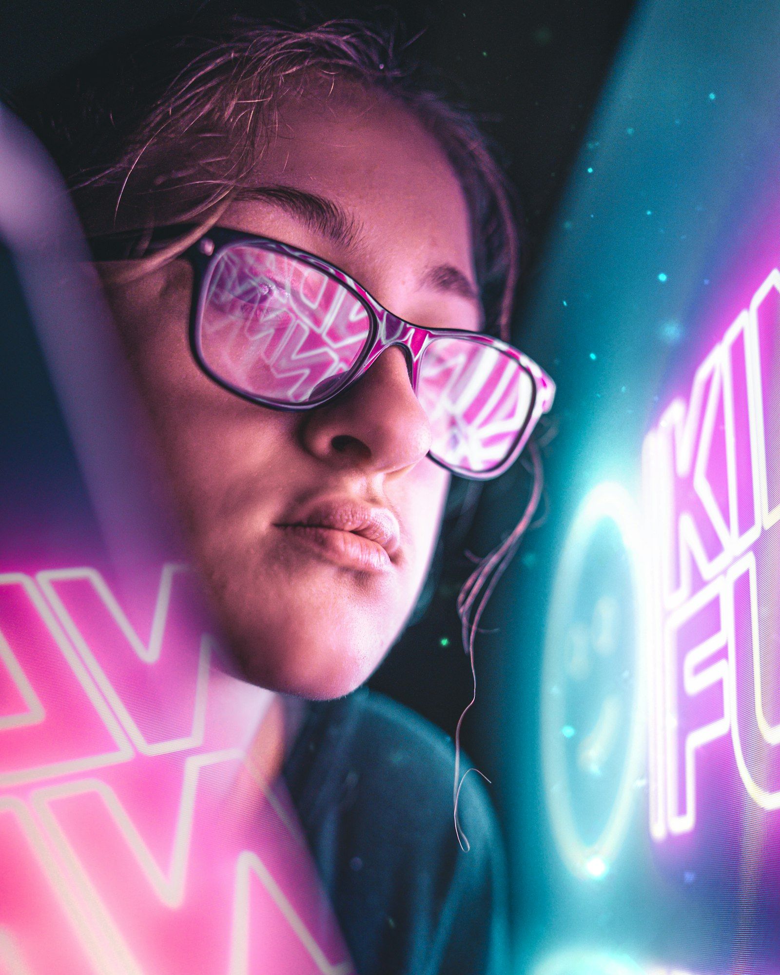 The image features a close-up of a young woman wearing glasses, with colorful reflections visible in the lenses. The background is adorned with vibrant neon text, creating a dynamic and modern atmosphere.
