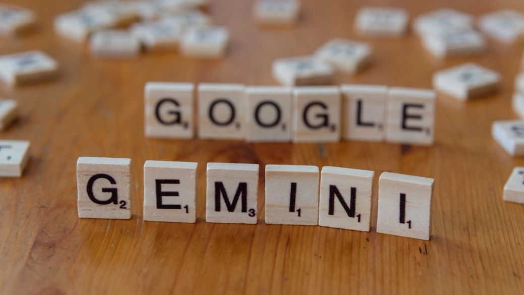 The image features wooden letter tiles arranged to spell out the words 'GOOGLE' and 'GEMINI' on a wooden surface. The composition highlights the playful and creative use of letter tiles, commonly associated with word games. — Credit: Photo by Markus Winkler / Unsplash