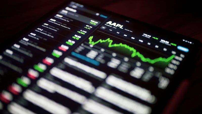 The image shows a close-up of a tablet screen displaying stock market data, with an emphasis on the stock performance of Apple Inc. (AAPL). Various stock prices and charts are visible, indicating active trading activity.