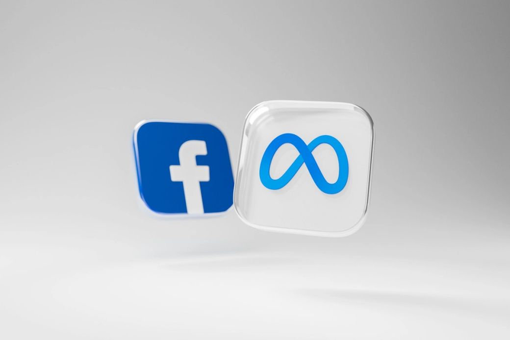 The image features the logos of Facebook and Meta, with a focus on the evolving brand identity of the social media company. The logos are depicted in a 3D style against a neutral background, symbolizing a transition in branding. — Credit: Photo by Dima Solomin / Unsplash