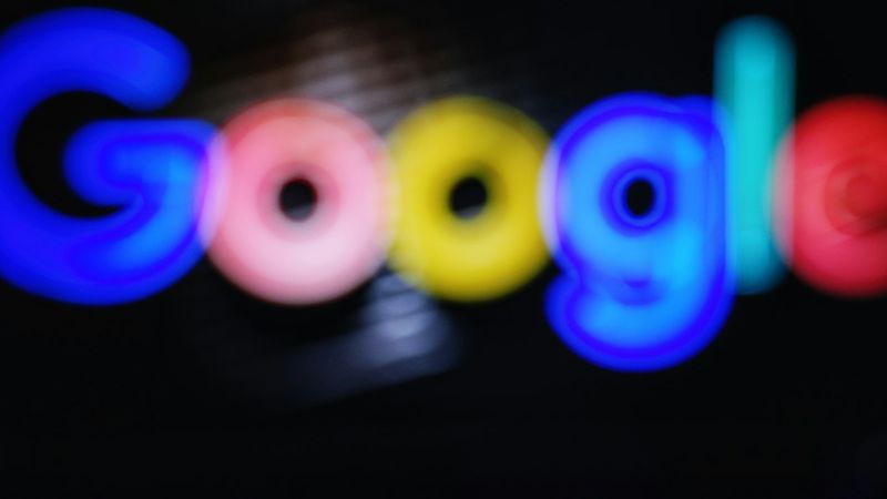 The image features a blurred depiction of the Google logo prominently displayed in various colors. The focus appears to be on the logo itself, emphasizing the brand's identity through its distinctive lettering.