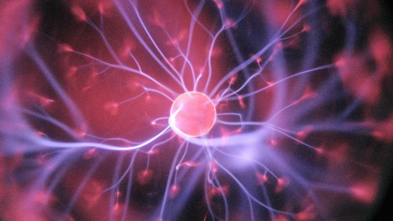 The image depicts a close-up view of a plasma globe, showcasing vibrant electrical arcs extending from a central sphere. The swirling colors and dynamic patterns create a visually striking representation of electrical energy.