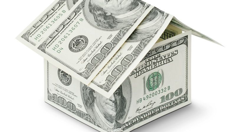 The image depicts a box made of U.S. one hundred dollar bills, symbolizing wealth or financial investment. The open box suggests the concept of opportunity or financial planning.