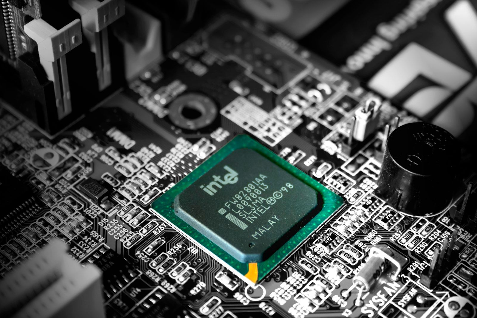 The image displays a close-up view of a computer motherboard featuring an Intel microprocessor. The intricate circuit board includes various electronic components, emphasizing the technology within computer hardware.