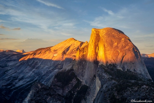 Yosemite Ulusal Parkı'ndaki Glacier Point'ten altın saatte görülen görkemli Half Dome granit monoliti.