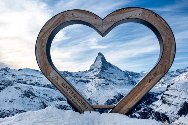 İsviçre Alpleri'nin üzerinde yükselen görkemli Matterhorn zirvesi, Zermatt yakınlarındaki karla kaplı yamaçlar ve alpin çayırlarla birlikte.