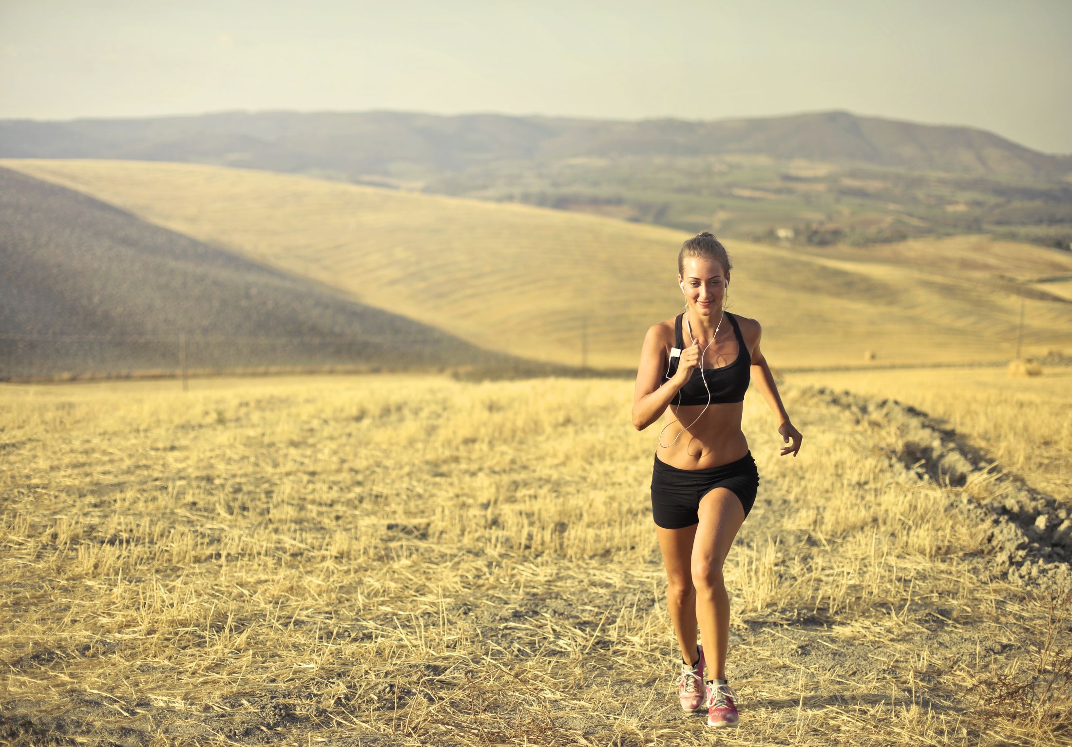 Runner training outdoors among sunlit rolling hills