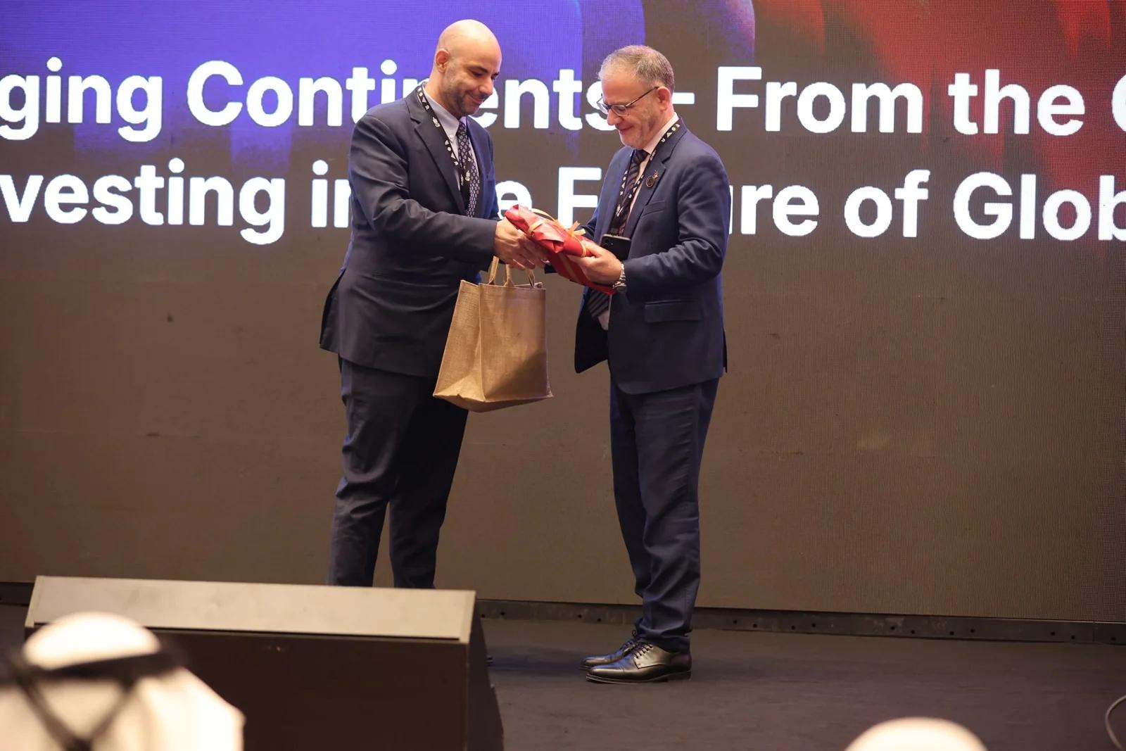 A greeting and gift exchange on stage at GIF Georgia 2025.