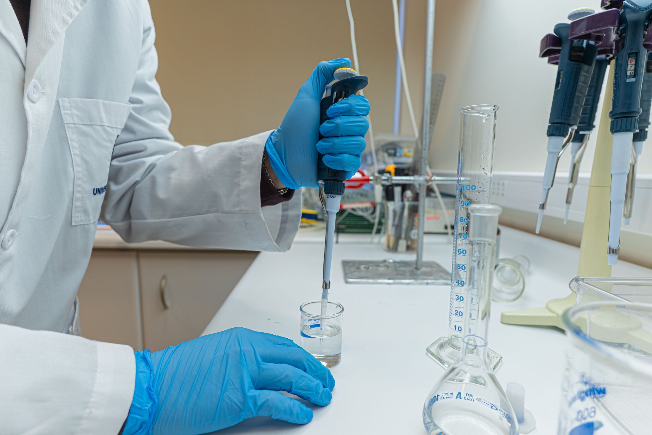 Lab scientist using pipette in chemical experiment with precision.