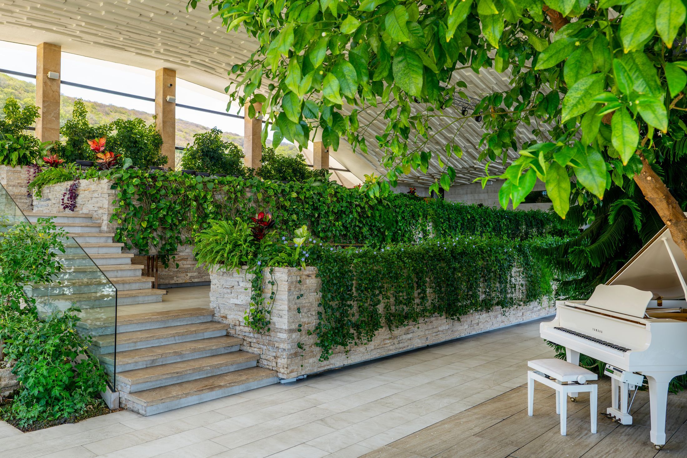 Elegant indoor garden with piano, showcasing modern green architecture in Tbilisi, Georgia.