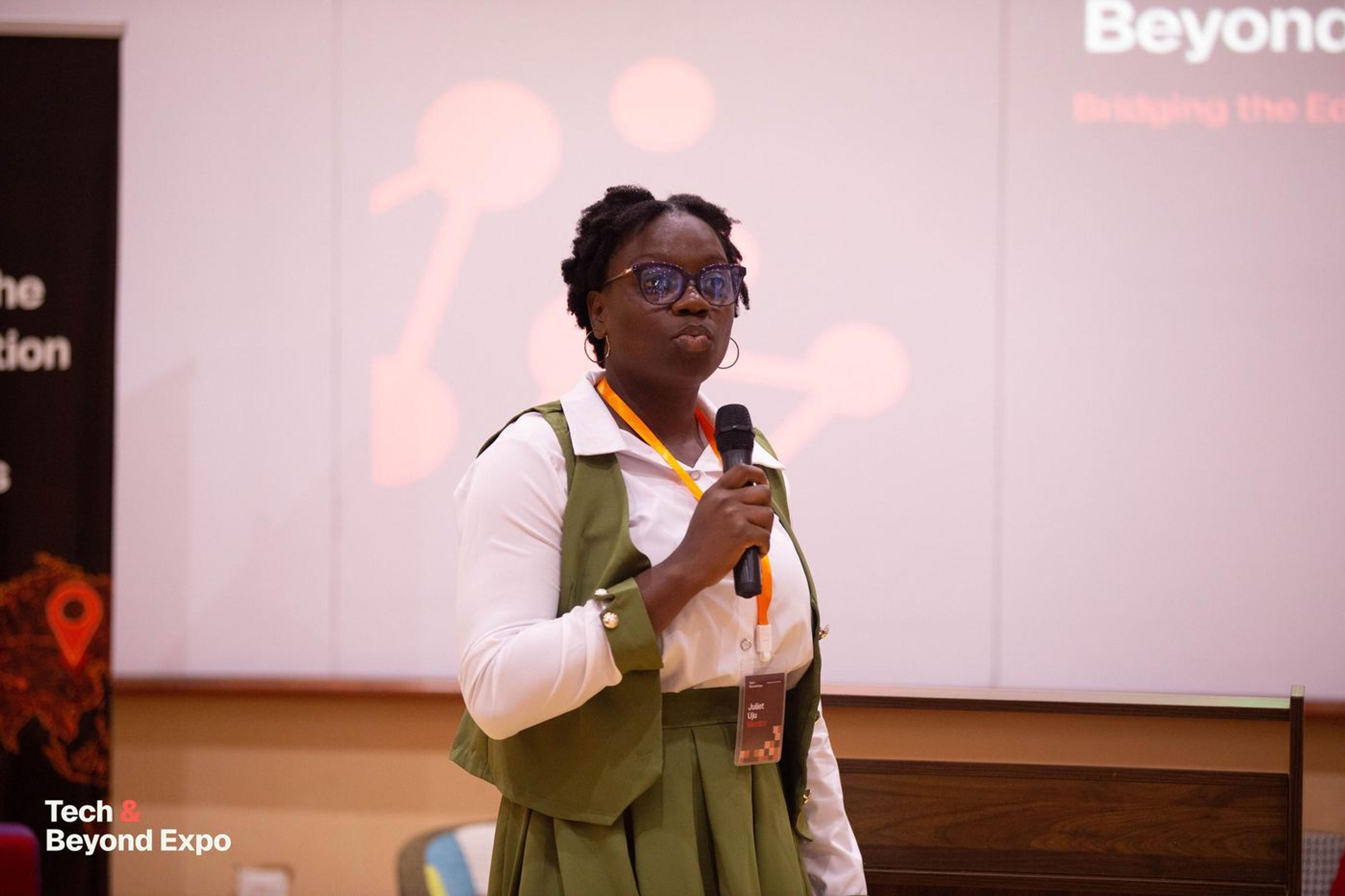 A speaker presenting in front of the Tech & Beyond Expo screen