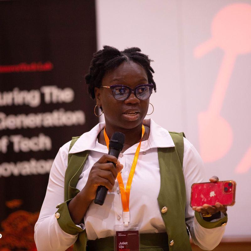 A speaker with a microphone presenting on stage