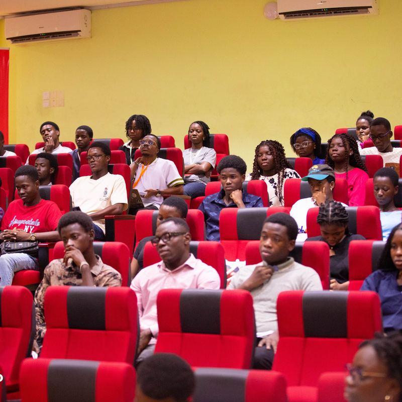 A full lecture hall of attendees listening