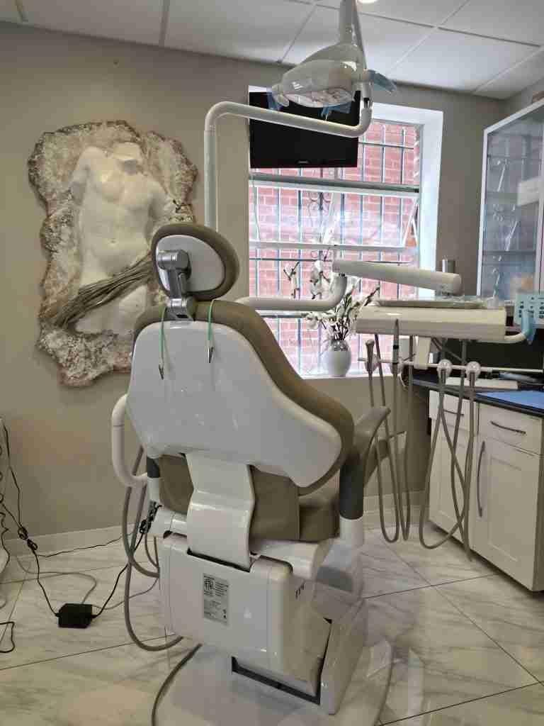 Treatment room with a dental chair and sculpture on the wall