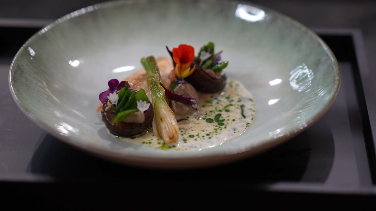 A plated dish with stuffed mushrooms, spring onion and edible flowers at Mount Med Resort