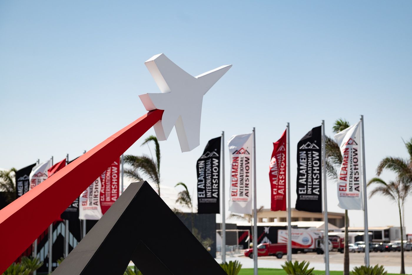 The El Alamein International Airshow 2026 entrance, with show flags and the jet sculpture