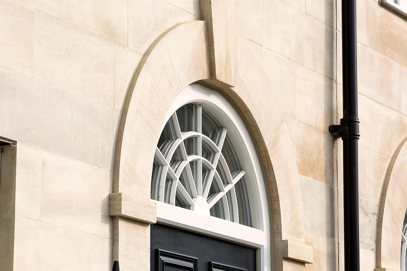 A fanlight window above the door and stone dressings around the arch