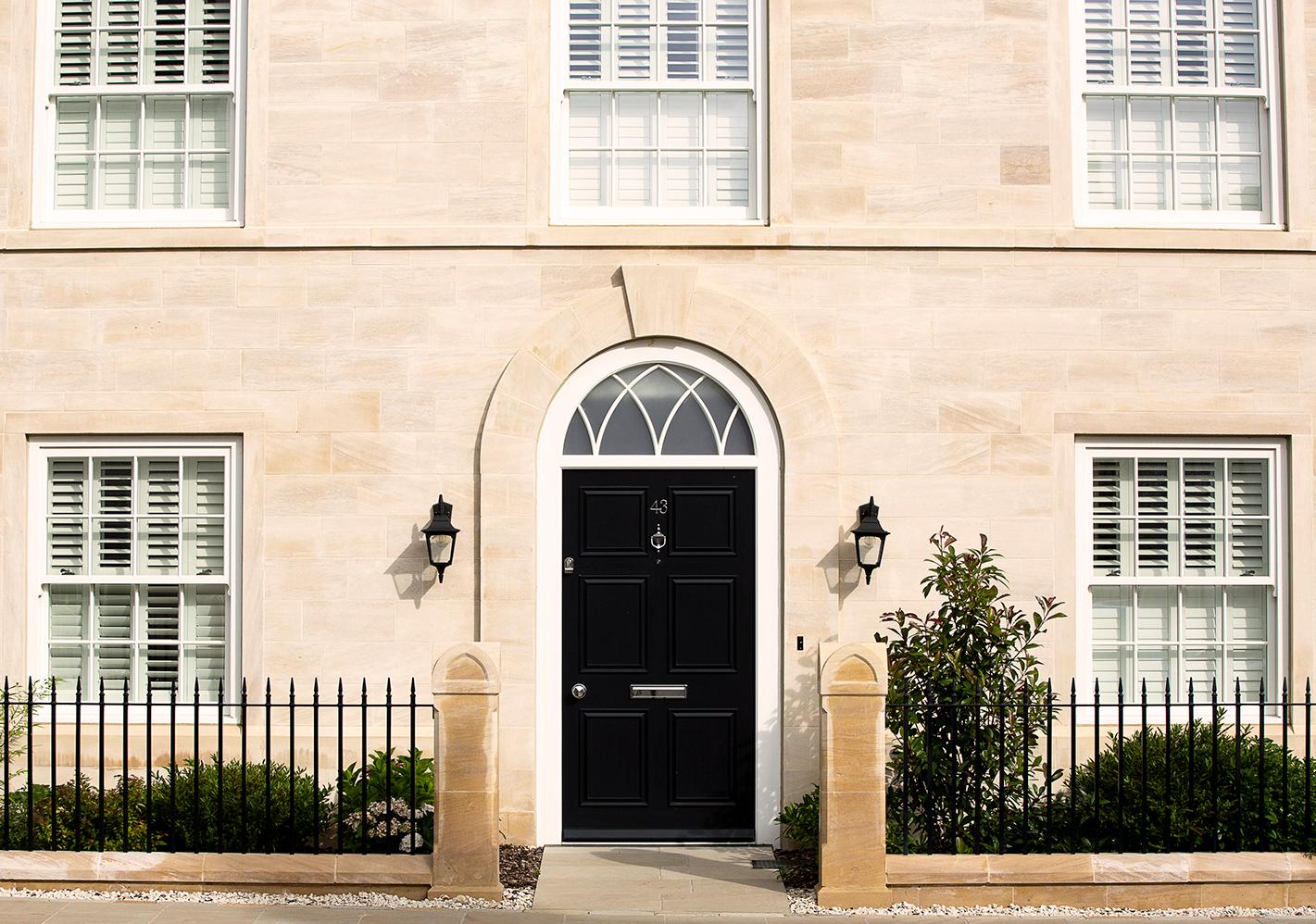 Georgian style home with sash windows and black metal railings