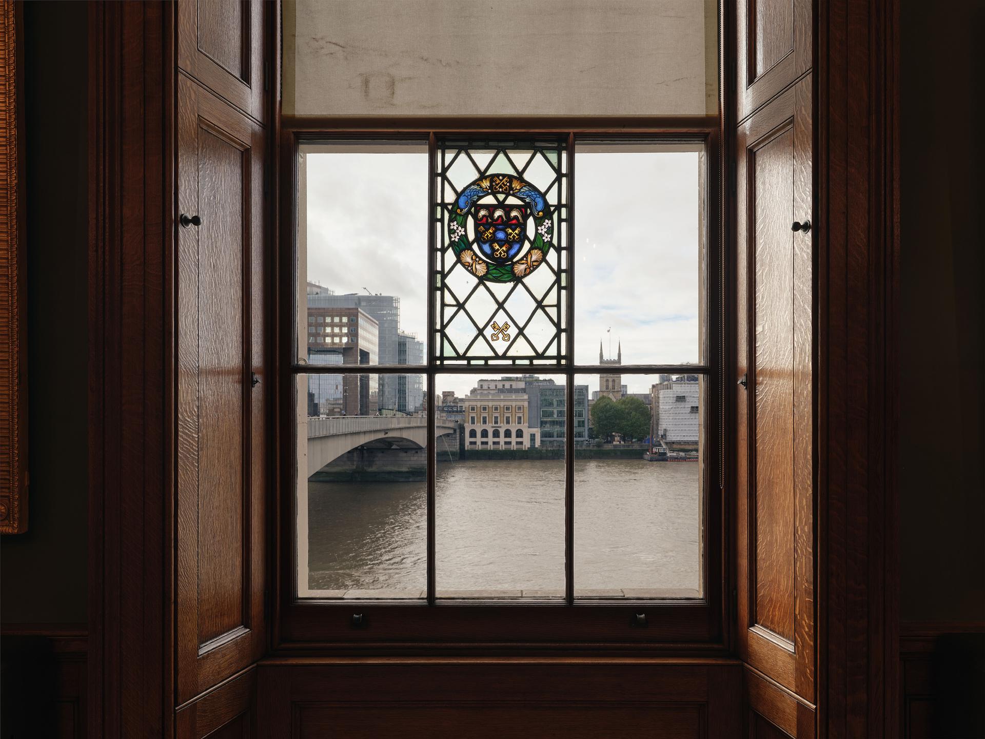 View out across the Thames through a Georgian style window with a central stain glassed panel