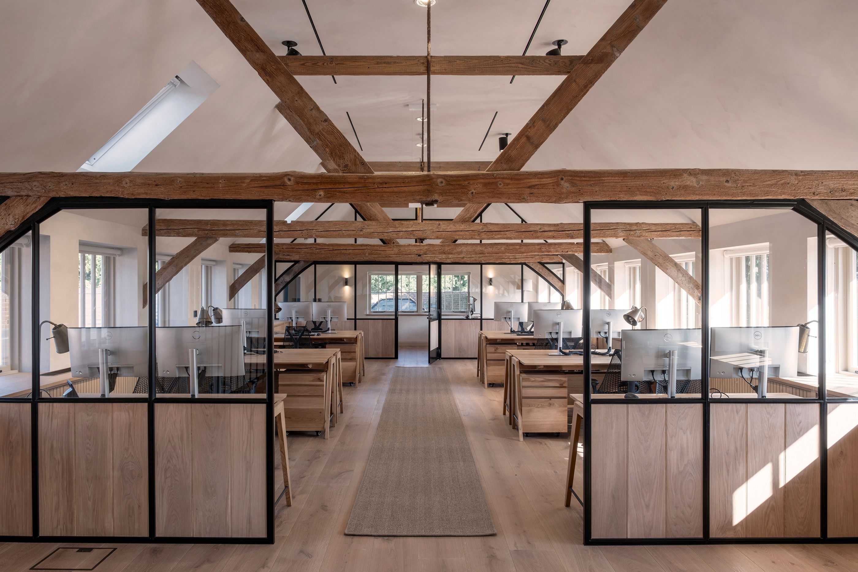 Open plan office with oak beams and glazed partitions 