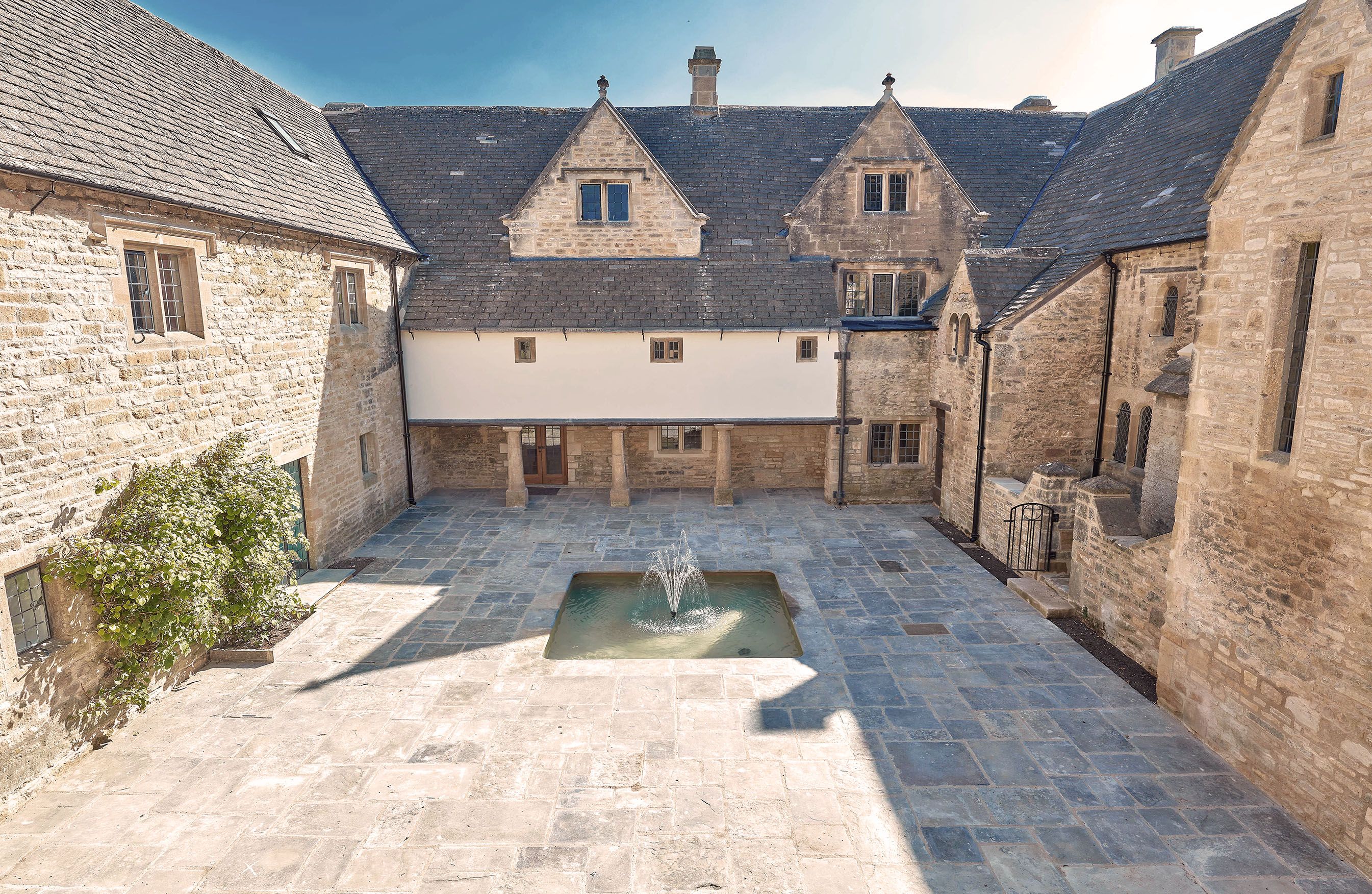 Cotswold manor house courtyard with central feature fountain 
