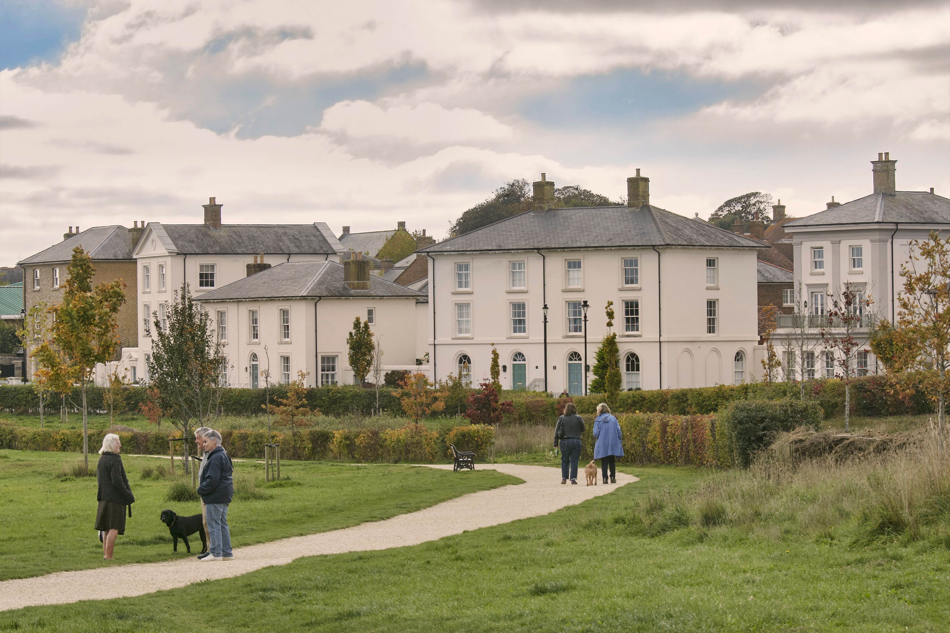 Dog walkers on The Great Field, view across to Georgian style houses along Dukes Parade