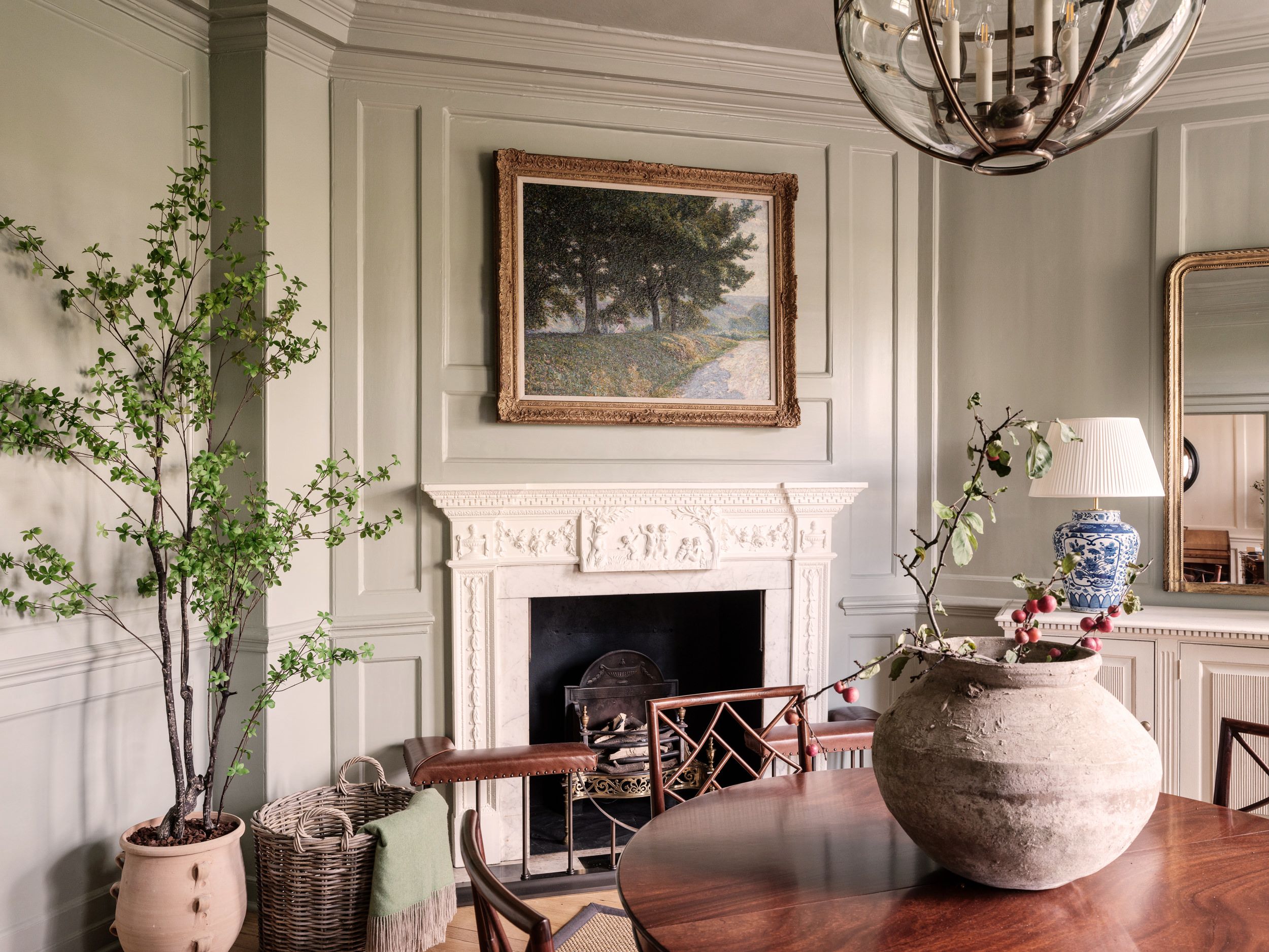Entrance hall with feature fireplace, artwork, central table and ornaments   