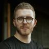 a man with a beard wearing glasses and a black shirt